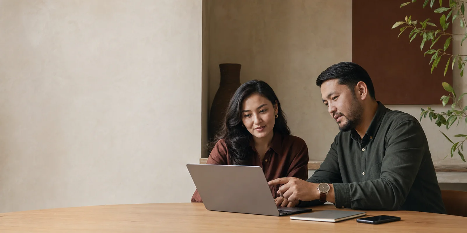 Two Central Asian career mentors reviewing work together at a table